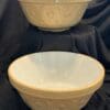 Two bowls are sitting on a table with black cloth.