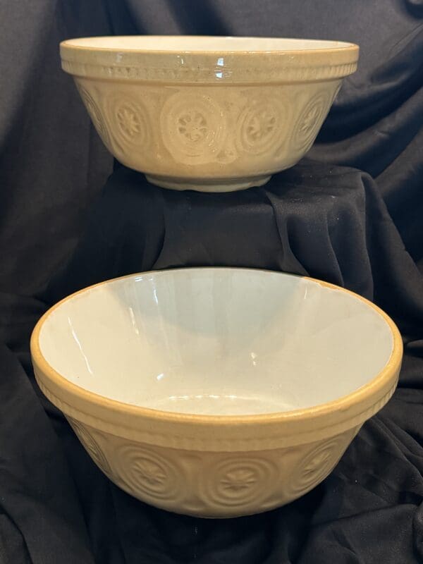 Two bowls are sitting on a table with black cloth.