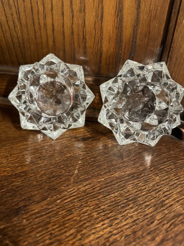 A pair of glass knobs on a wooden table.