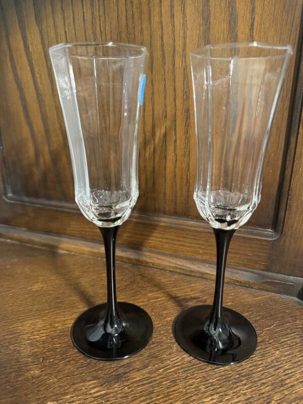 Two champagne glasses sitting on top of a wooden table.