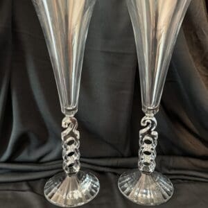 A pair of silver champagne flutes with twisted stems.