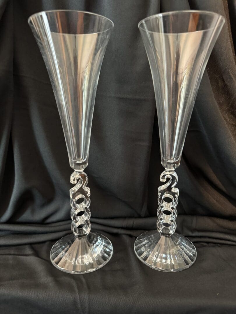 A pair of silver champagne flutes with twisted stems.