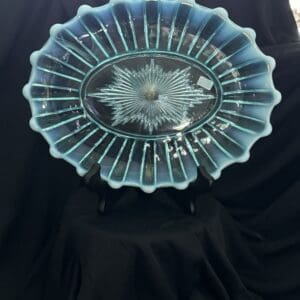 A blue glass bowl with a black stand