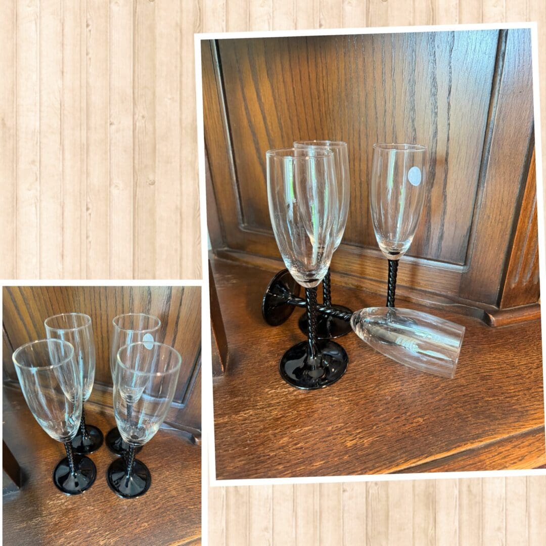 A set of four wine glasses on top of a wooden table.