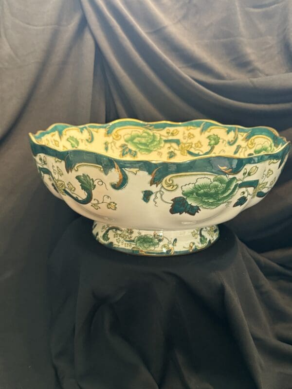 A bowl with green and yellow designs on it.