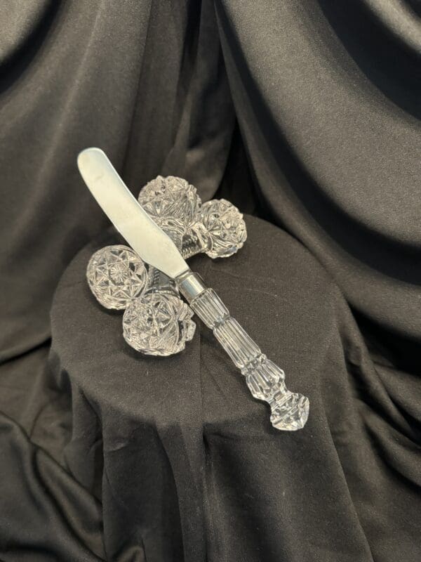 A knife and some cookies on top of a black cloth.