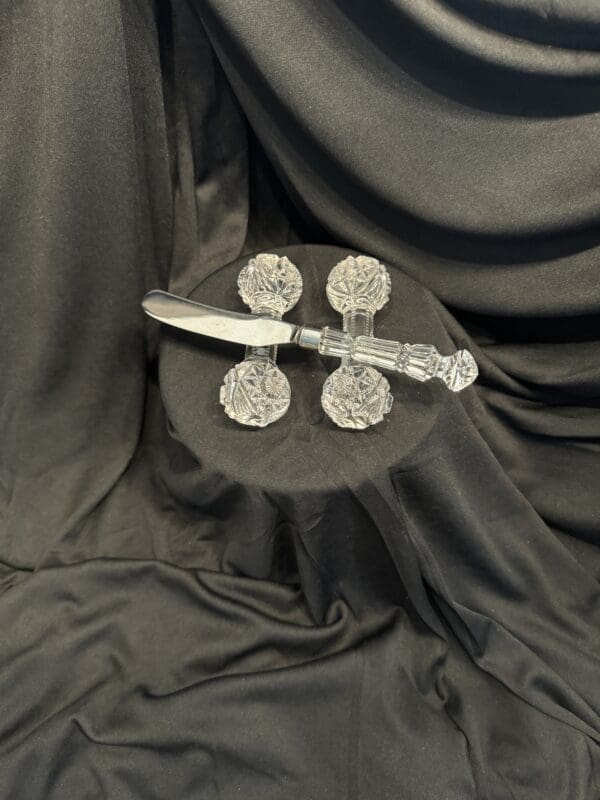 A knife and four plates on top of black cloth.