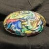 A colorful stone sitting on top of a couch.