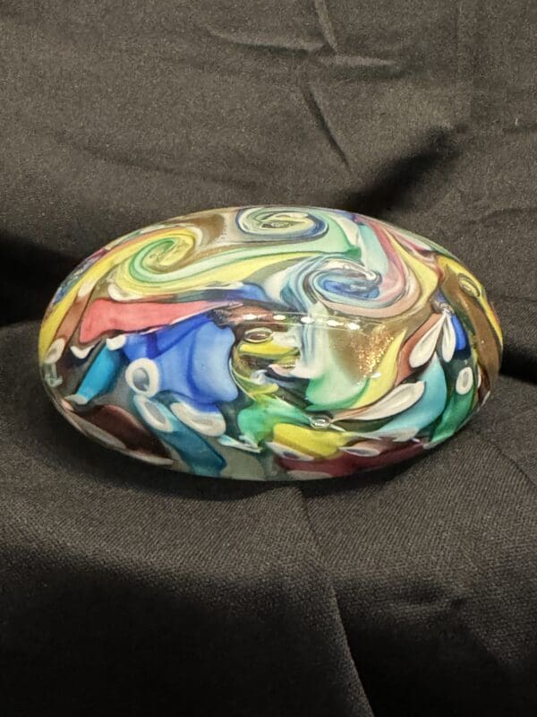 A colorful stone sitting on top of a couch.