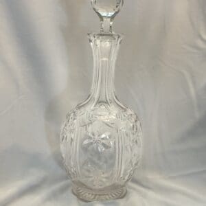 A clear glass vase with a lid on top of it.