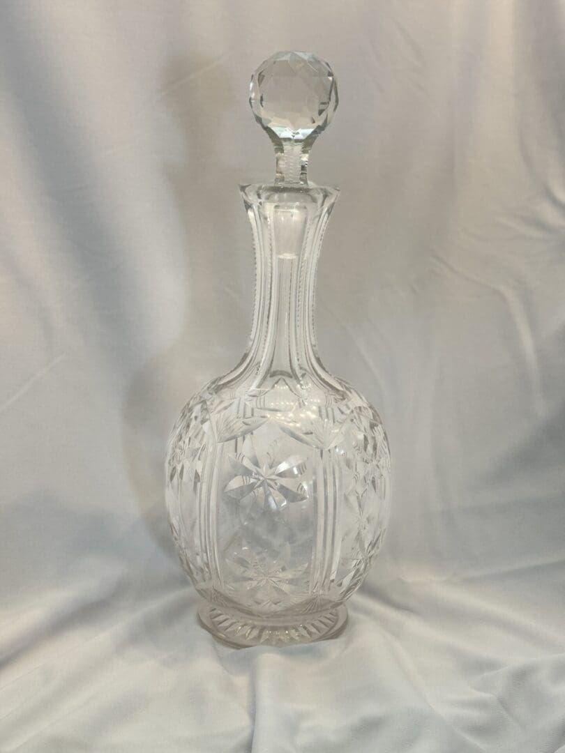 A clear glass vase with a lid on top of it.