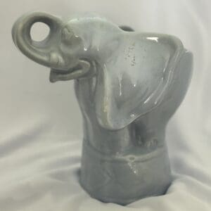 A gray elephant statue sitting on top of a table.