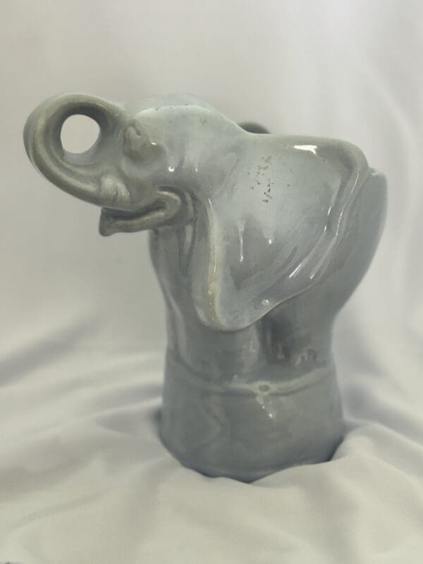 A gray elephant statue sitting on top of a table.