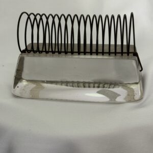A metal object with black wire attached to it.
