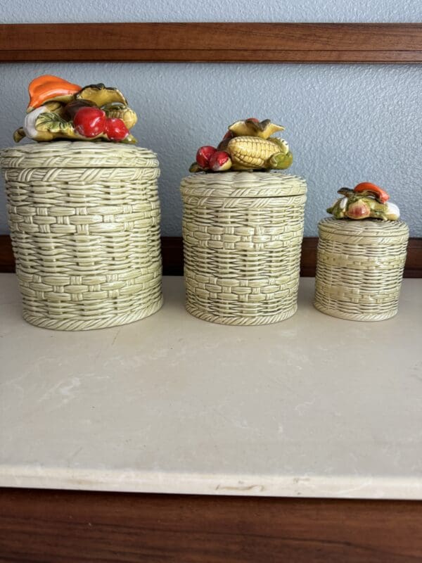 Three canisters with different sized lids on a counter.