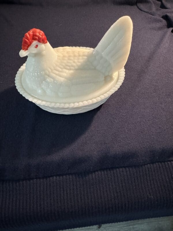 A white chicken sitting on top of a plate.