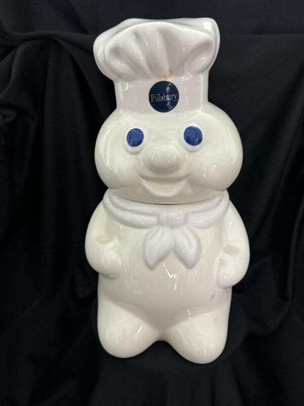 A white pillsbury doughboy statue wearing a chef 's hat.