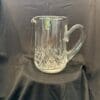 A glass pitcher sitting on top of a table.