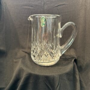 A glass pitcher sitting on top of a table.