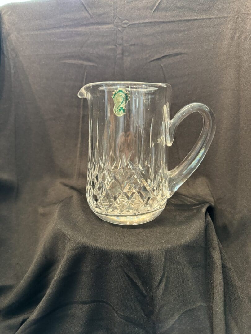 A glass pitcher sitting on top of a table.