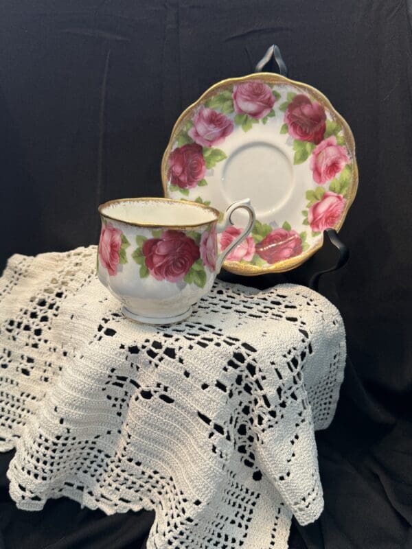 A cup and saucer on a table with lace