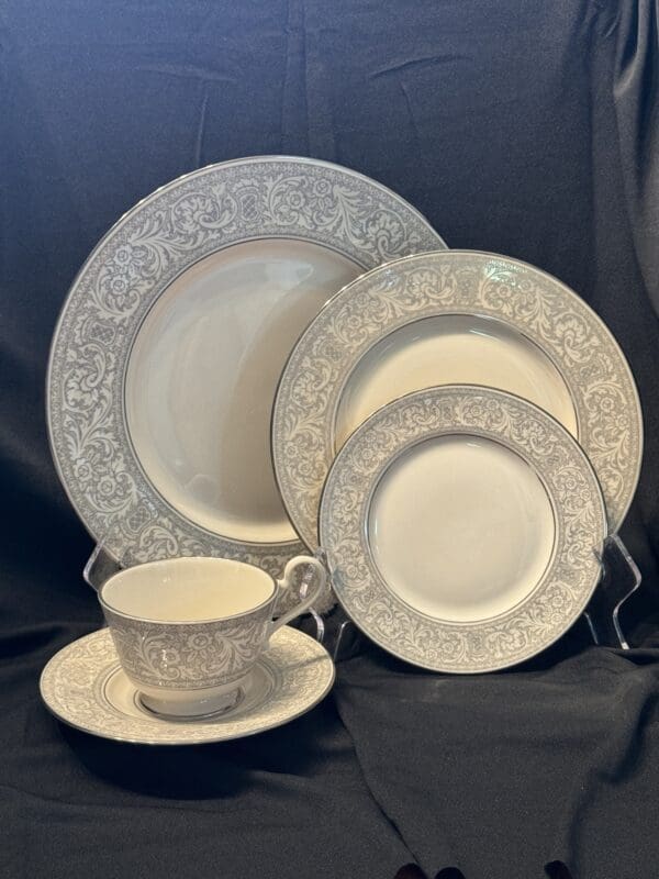 A white and silver plate set with tea cup.