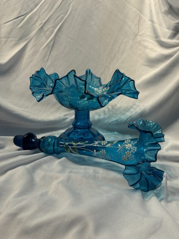 A blue glass vase with a handle and a umbrella.