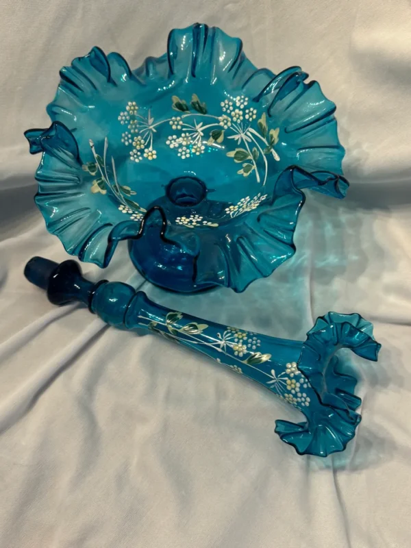 A blue glass dish and umbrella set with flowers.