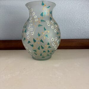 A glass vase with flowers painted on it