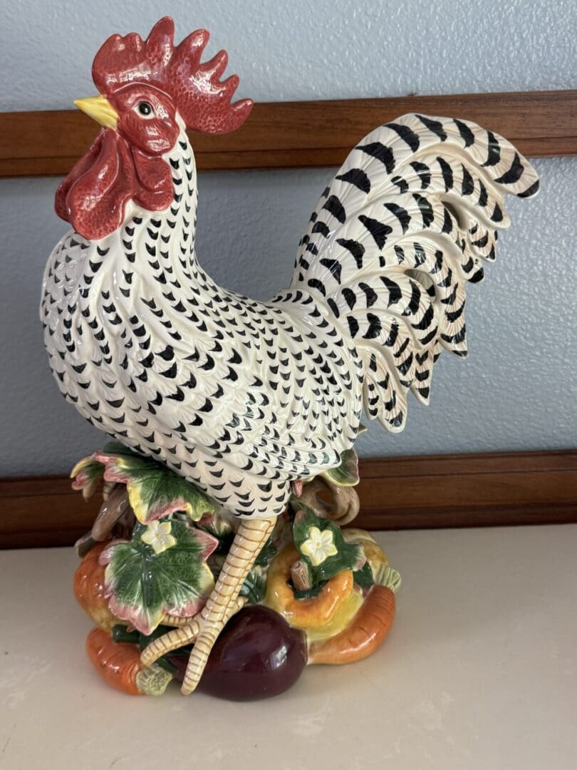 A black and white rooster on top of some fruit.