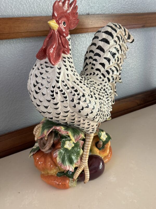 A rooster statue sitting on top of some vegetables.