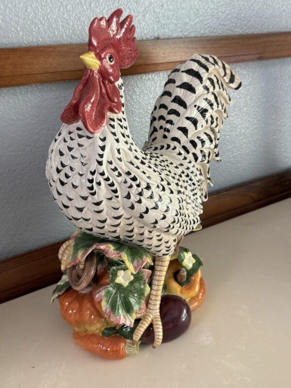 A rooster statue sitting on top of some vegetables.