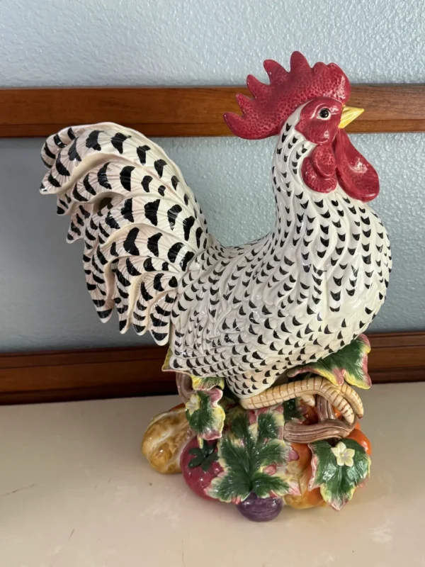 A black and white rooster sitting on top of a table.