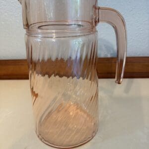 A glass pitcher sitting on top of a table.