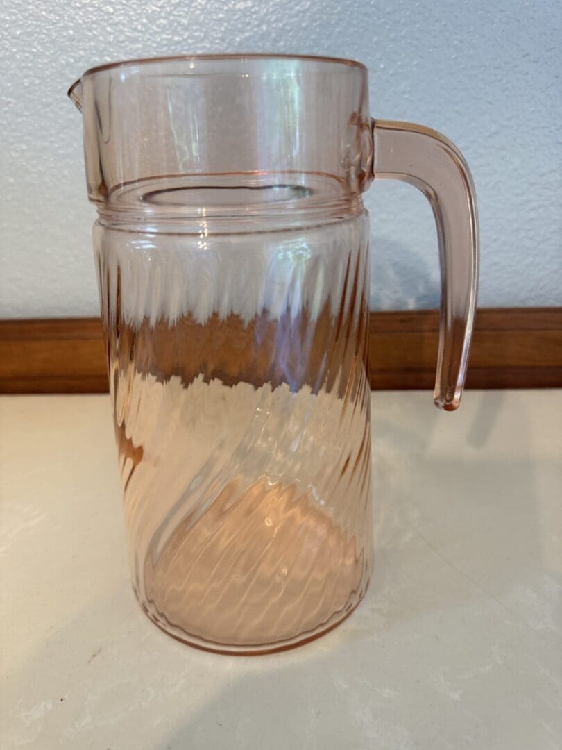 A glass pitcher sitting on top of a table.