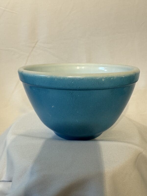 A blue bowl sitting on top of a table.