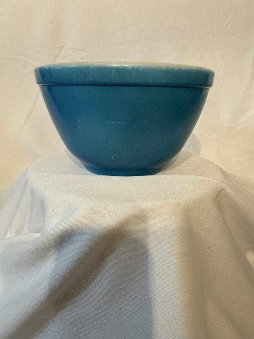 A blue bowl sitting on top of a white table.