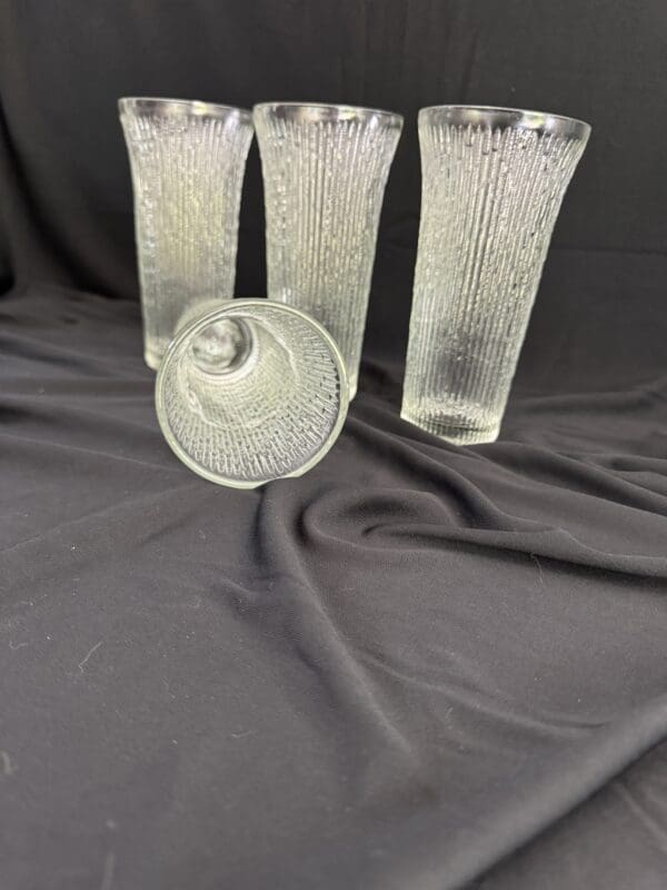 A set of four glass vases and one other vase.