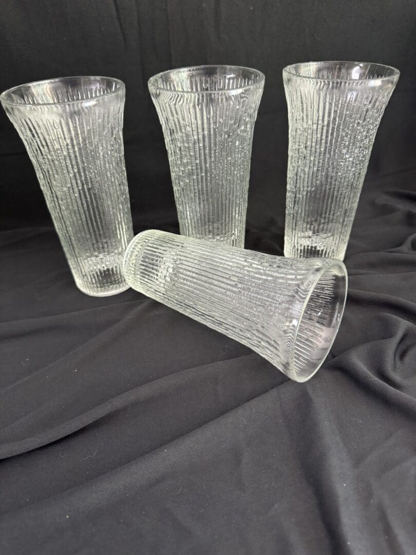 A group of four glasses sitting on top of a table.