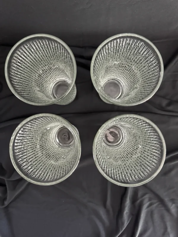 Four silver cups sitting on top of a black sheet.