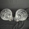Two ornate crystal glasses on black fabric.