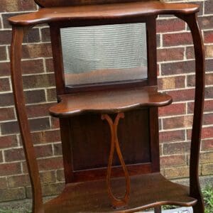 A wooden shelf with a mirror and two shelves.