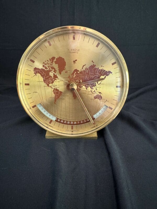 A gold clock with the world on it