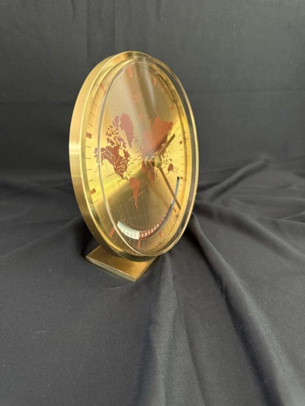 A gold clock sitting on top of a table.