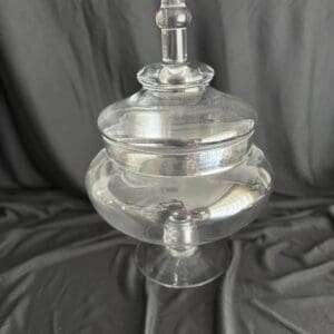 A glass jar with lid on top of a table.