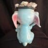 A blue elephant with money in its mouth.