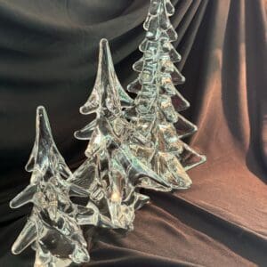 A group of three glass trees sitting on top of a table.