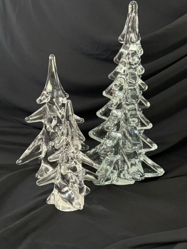 Two glass trees are sitting on a table.