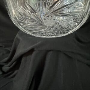 A glass vase sitting on top of black fabric.