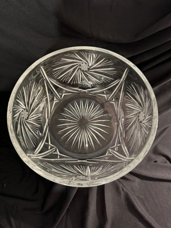 A glass bowl with a pattern of leaves and flowers.